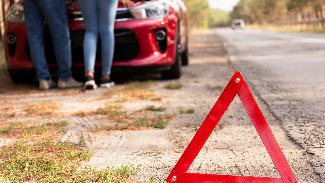 röd triangel vid väg och bil för att varna