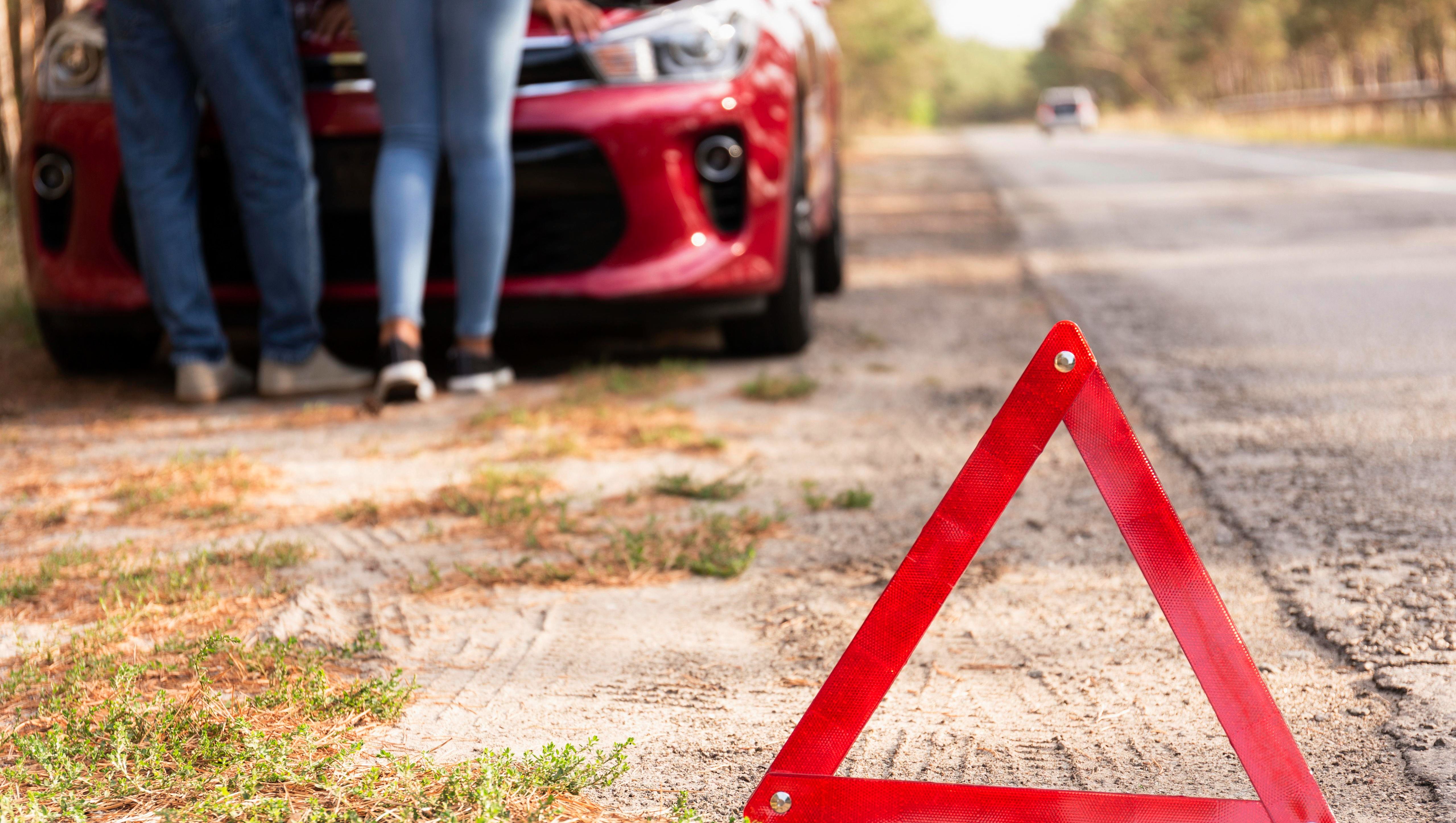 röd triangel vid väg och bil för att varna