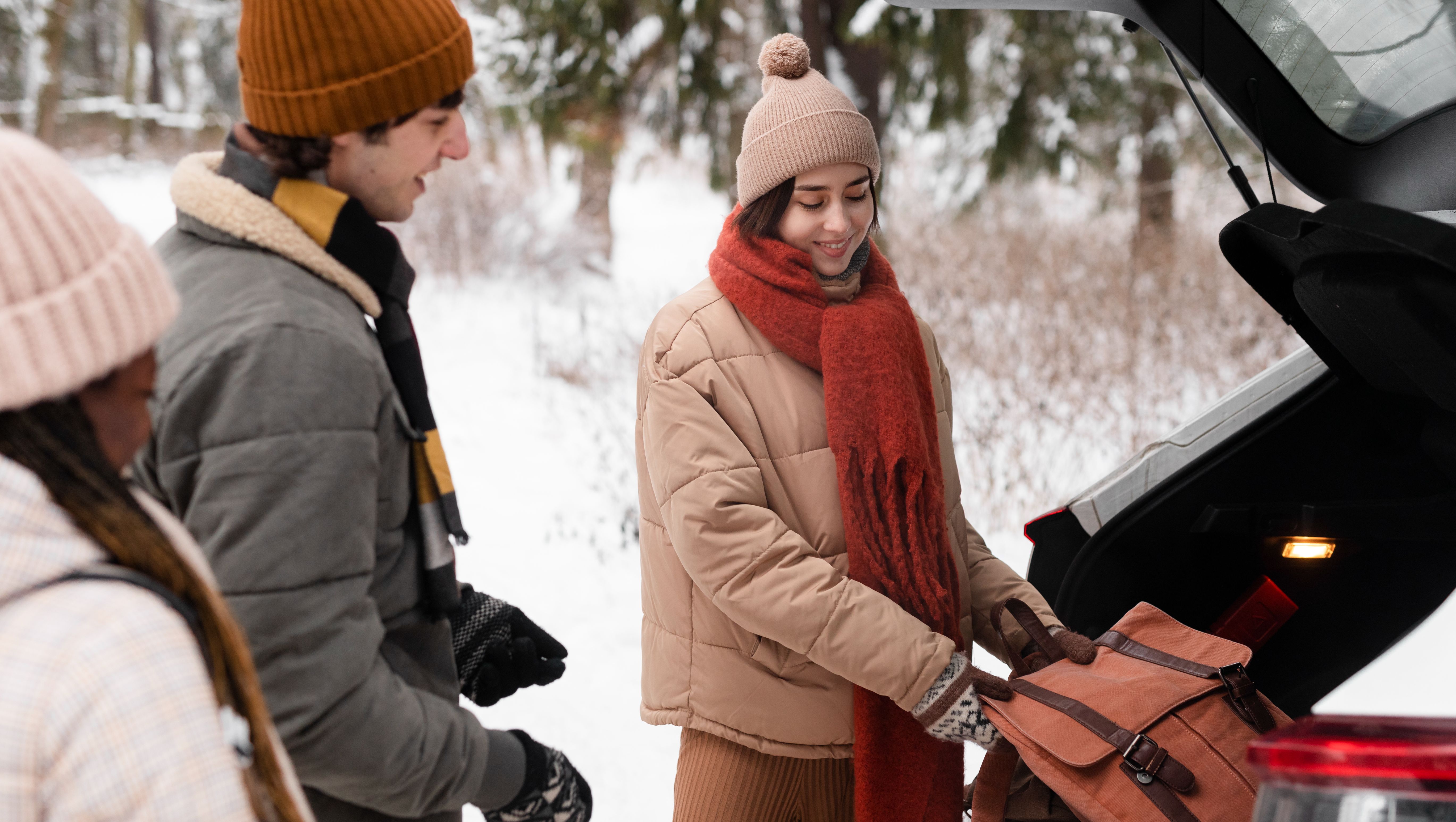 familj tar ut vinterkit ur bil en snöig dag
